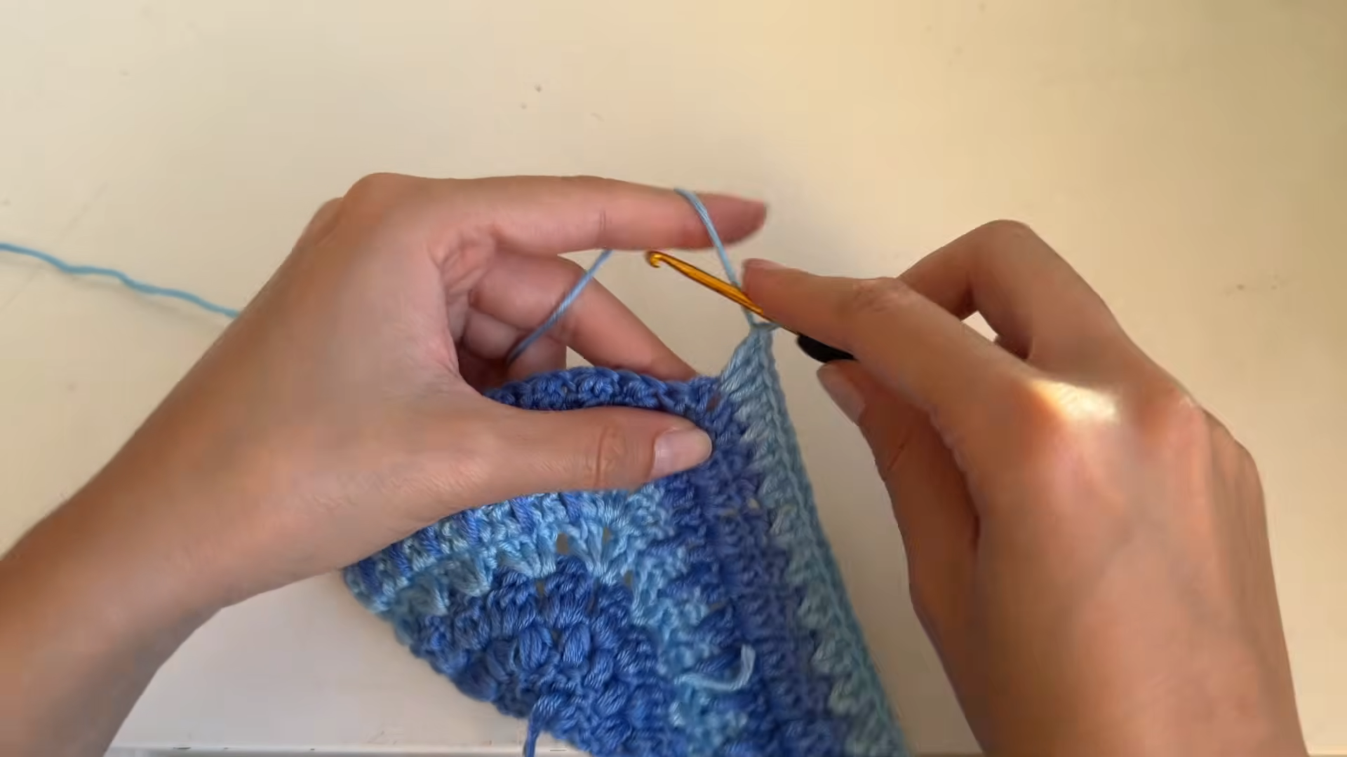 Crocheting rows on blue halter top