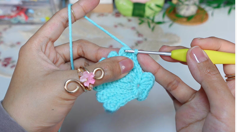 Finished blue crochet flower with hook