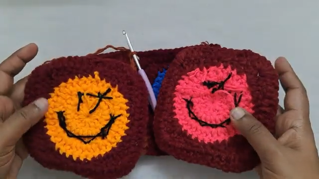 Finished crochet smiley face pouch with embroidered faces