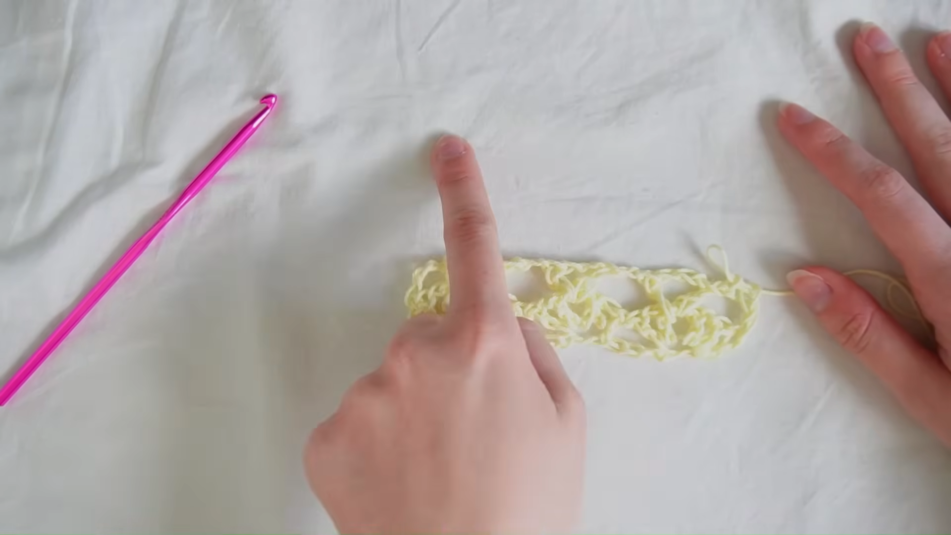 vRow of lacy crochet stitches in cream yarn