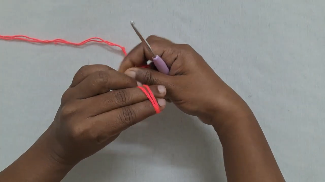 Slip knot with red yarn for smiley face pouch