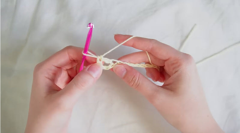 Working chain stitches with pink crochet hook