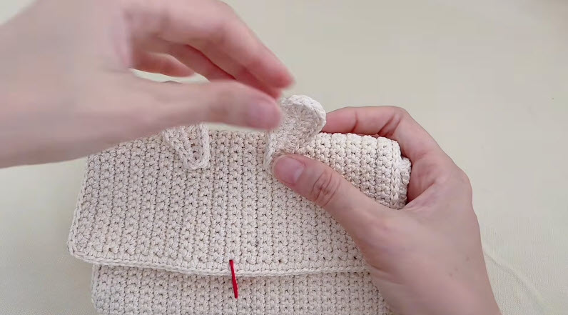 Attaching crochet rabbit ear onto the finished cream bag