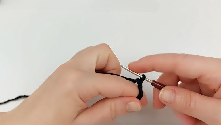 Black yarn magic ring with 6sc being crocheted, R1 of the body.