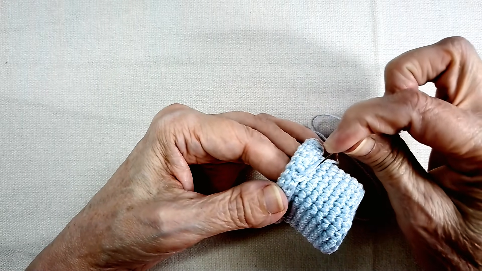 Blue pot rim folded and stitched with a needle.