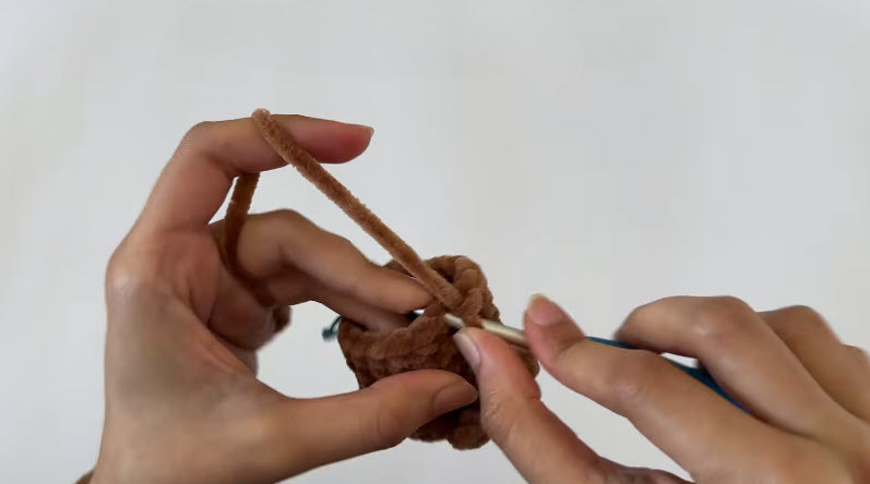Brown fluffy piece R11 bobbleBO stitches being crocheted with the hook.