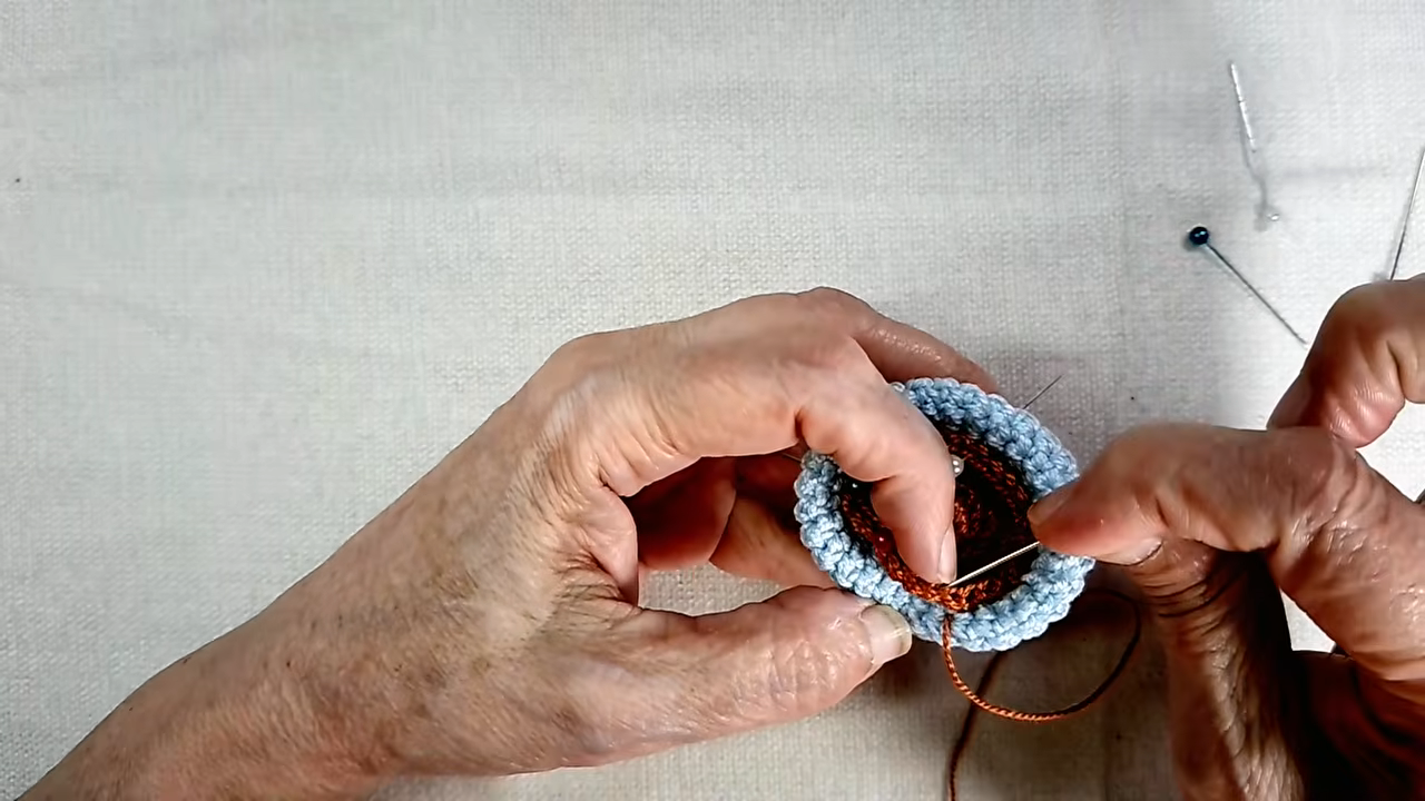 Brown soil disc pinned and sewn inside the blue pot.