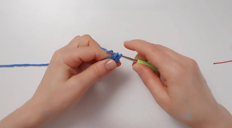 Crocheting six single stitches into peacock's magic ring