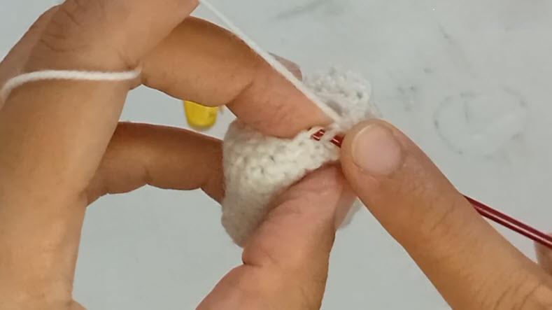 Decreasing stitches on white crochet tooth amigurumi