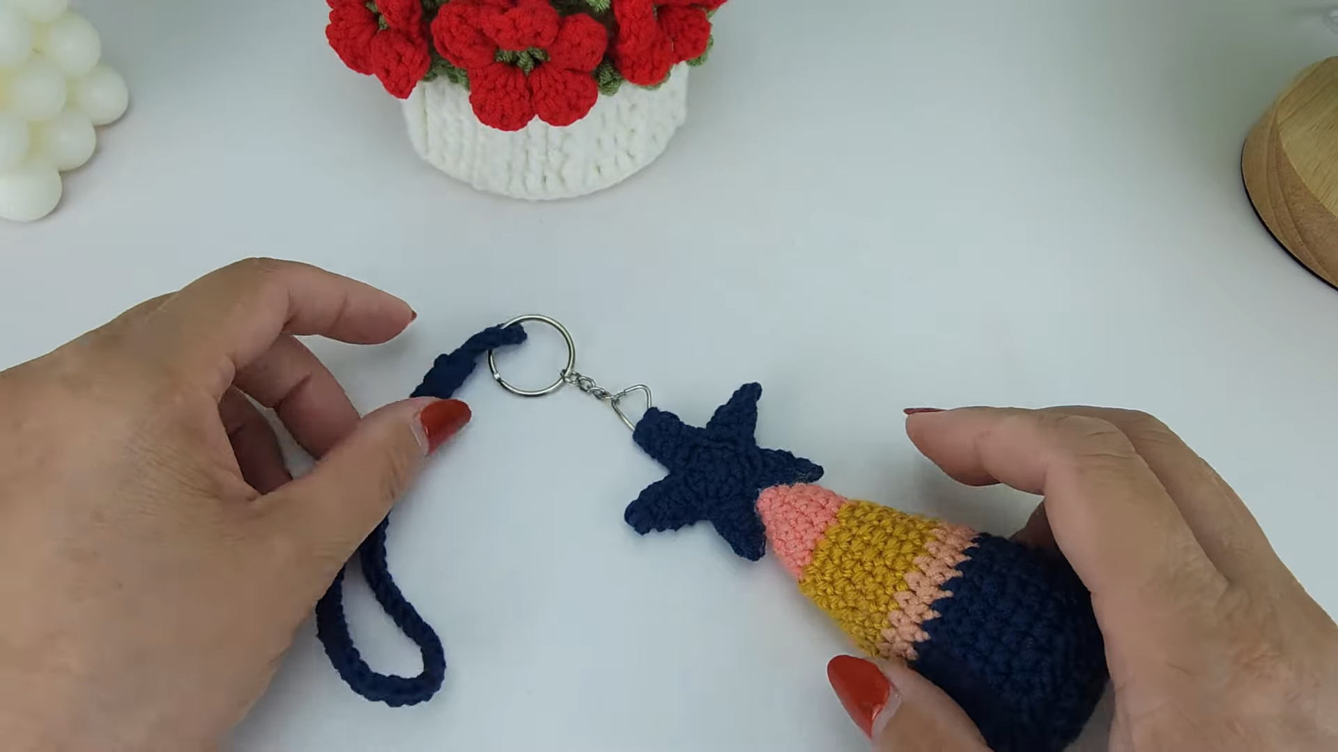 Finished pine tree keychain with navy star, striped cone, and crochet strap.