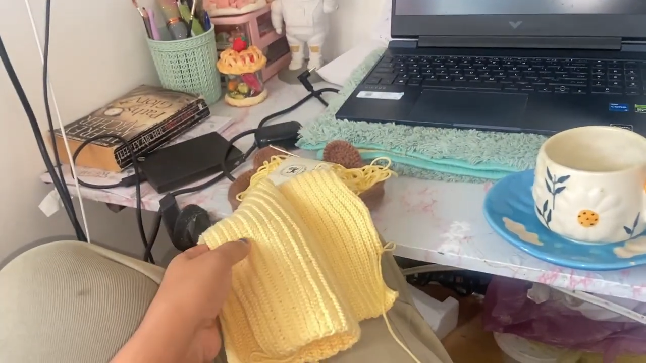Holding yellow crochet top piece in progress