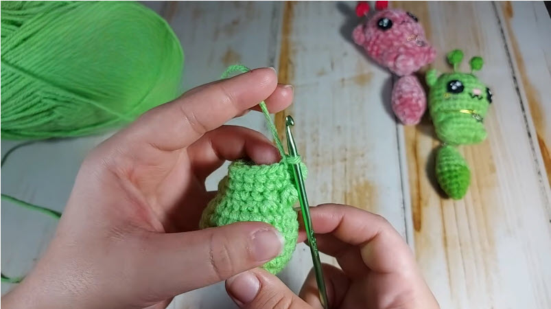 Making decrease stitches on green alien cat body