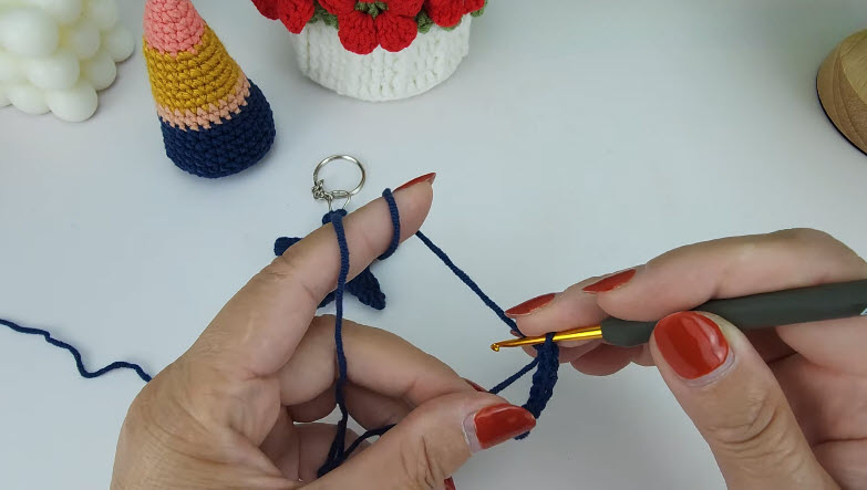 Navy strap being crocheted with a keyring attached at the top.