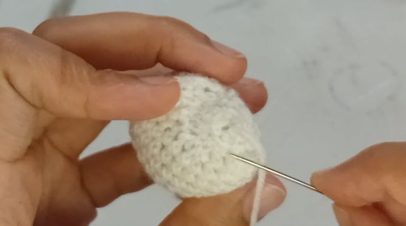 Sewing detail onto white amigurumi tooth