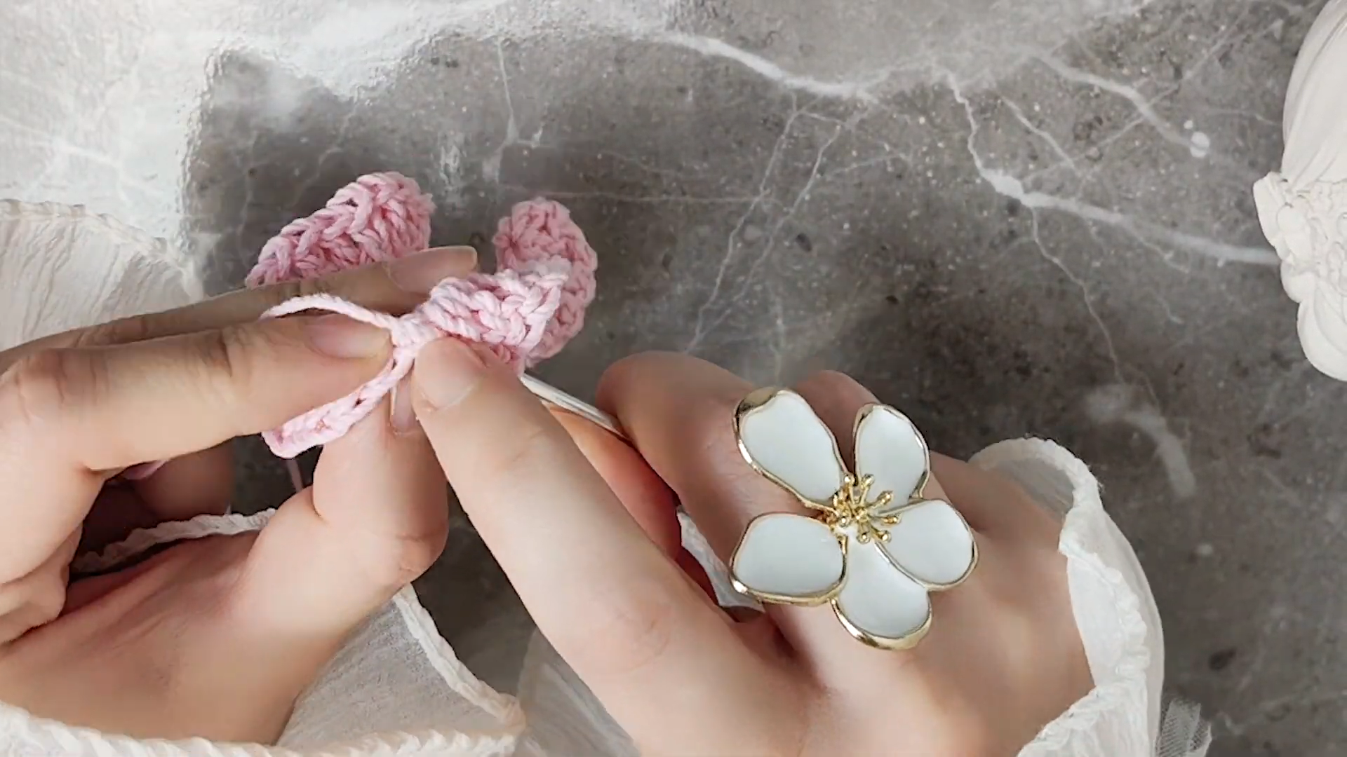 Shaping pink crochet petals for scarf rose flower