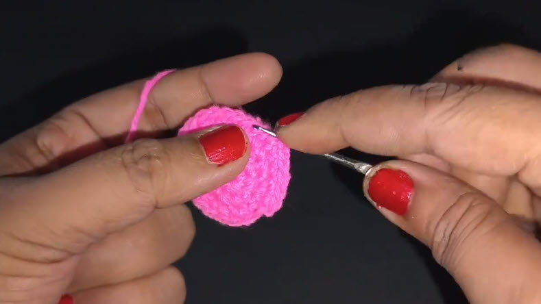 Single crocheting all around row four in pink