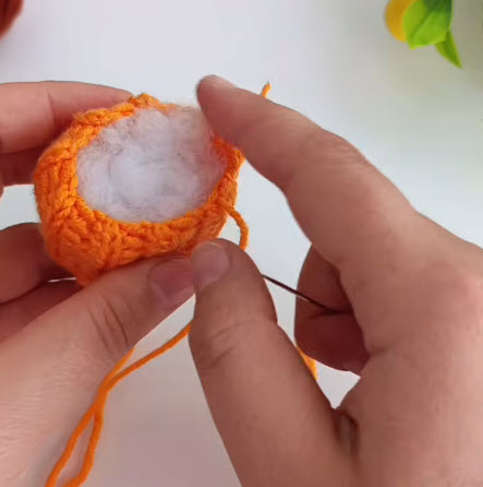 Fiberfill stuffing added inside the gathered crochet pumpkin body