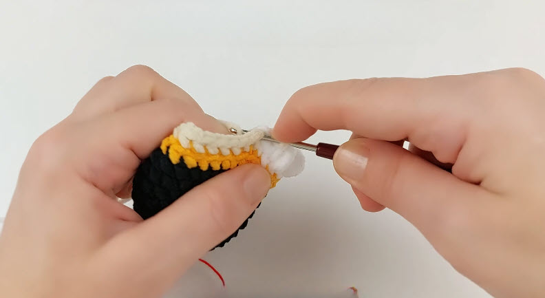 White, beige and black crochet piece R13 with bobble stitches forming the edge.