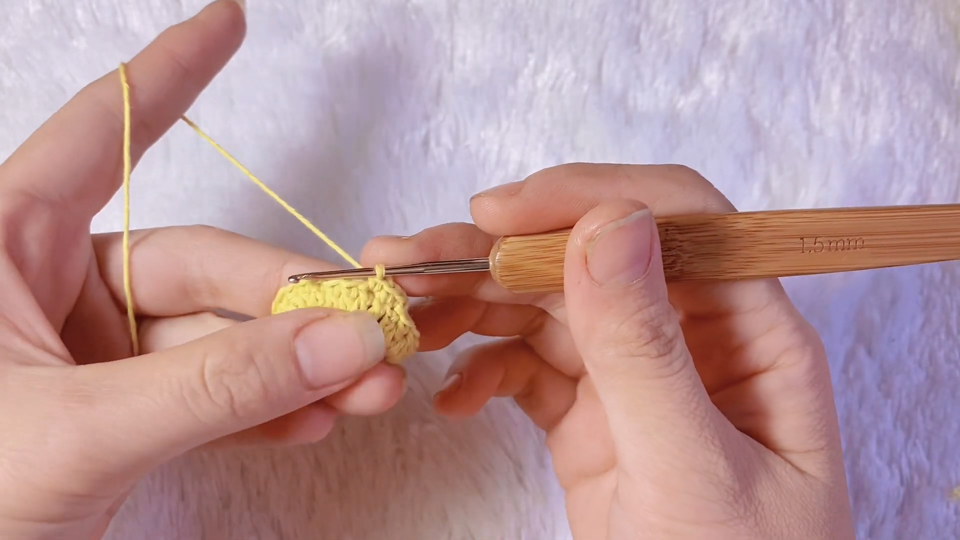Working single crochet stitches around yellow amigurumi base