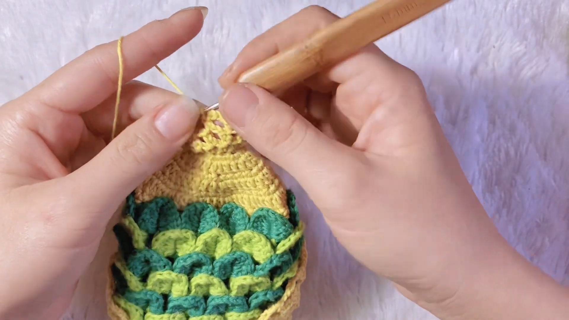 Yellow crochet fish head with green crocodile stitch body scales