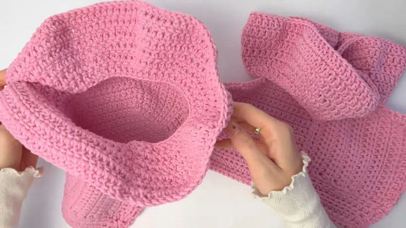 Assembled pink crochet piece with a wide rounded brim.