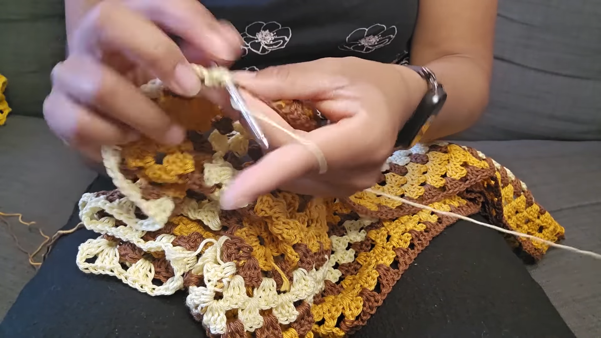 Crocheting a cream border along the granny stitches.