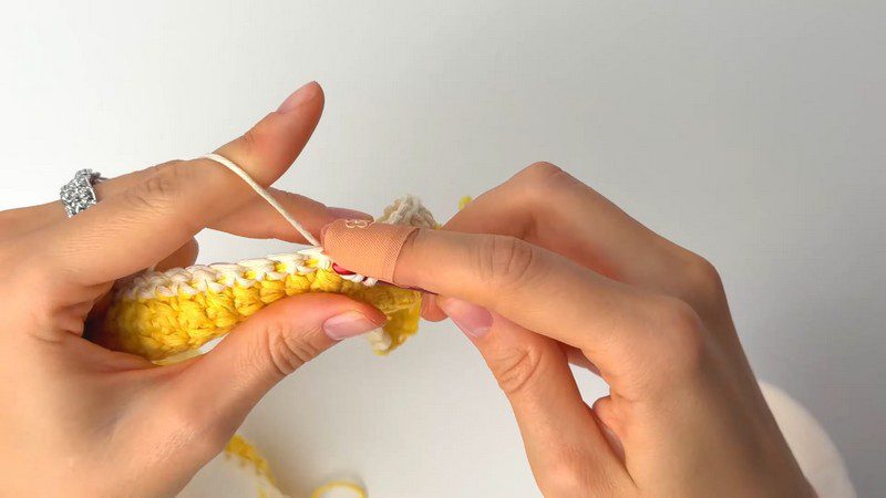 Textured yellow rows for the crochet placemat pattern on the hook.