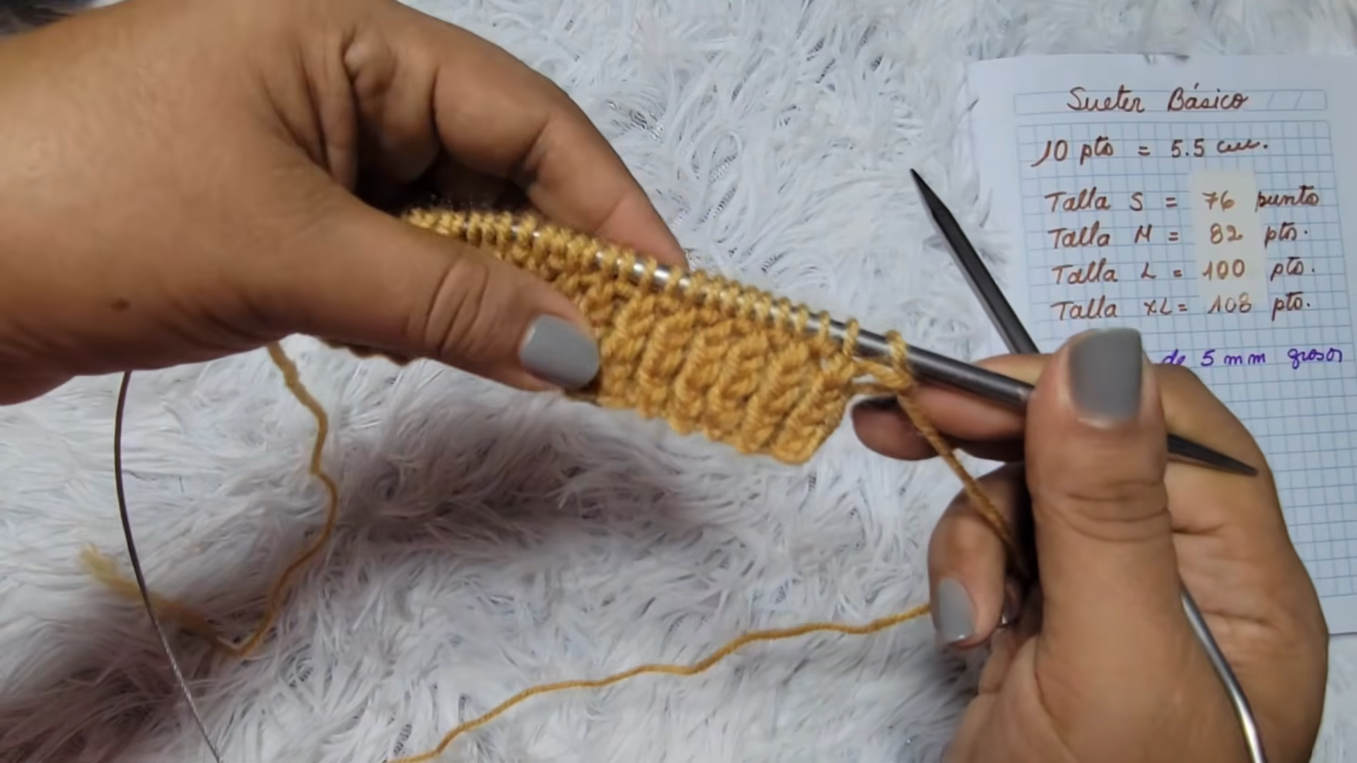 Knitting a mustard ribbed band beside the size chart notes.