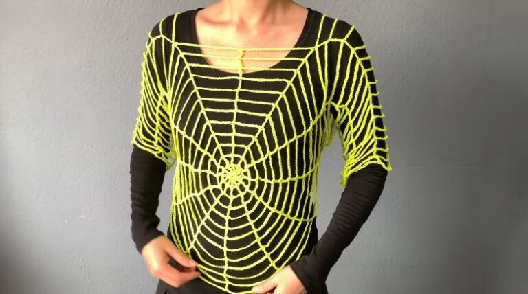 Neon yellow crochet spider web top worn over a black long sleeve shirt, with radiating web lines and a center spiral