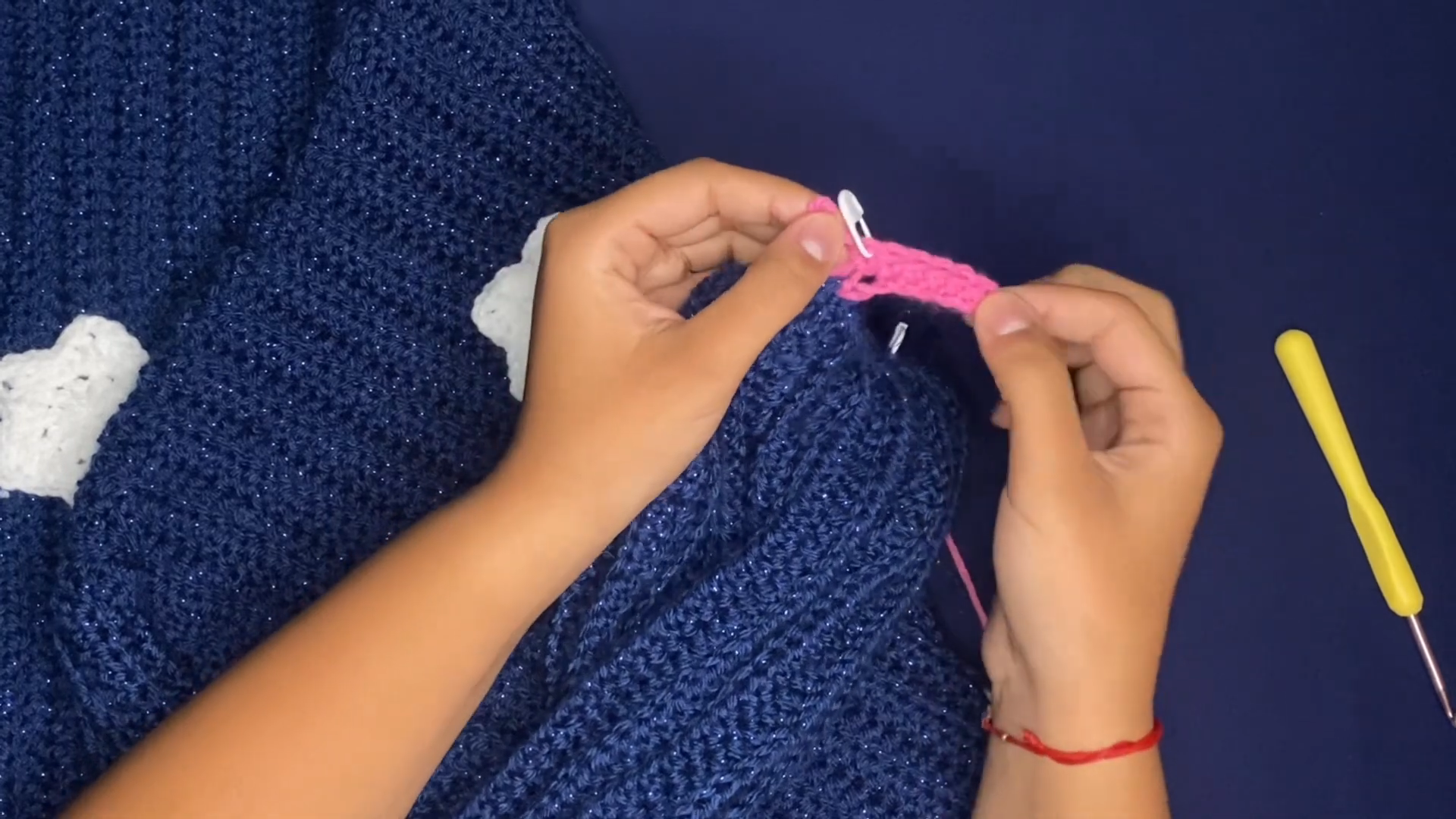 Pink strip with a white marker worked beside white stars on navy for the crochet Coraline sweater