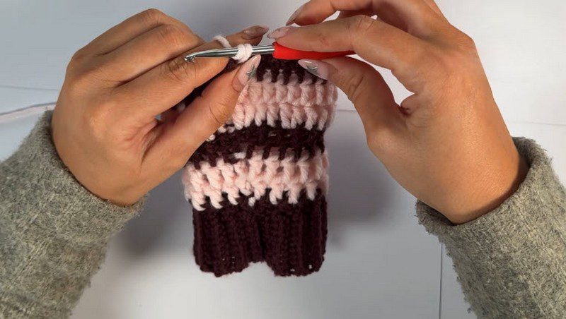 Pink and purple double crochet rounds above the ribbed band.