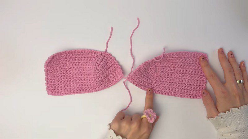 Two pink crochet panels laid flat before joining.