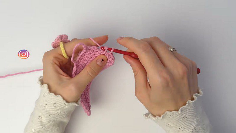 Working the first rows of the pink panel with a hook.
